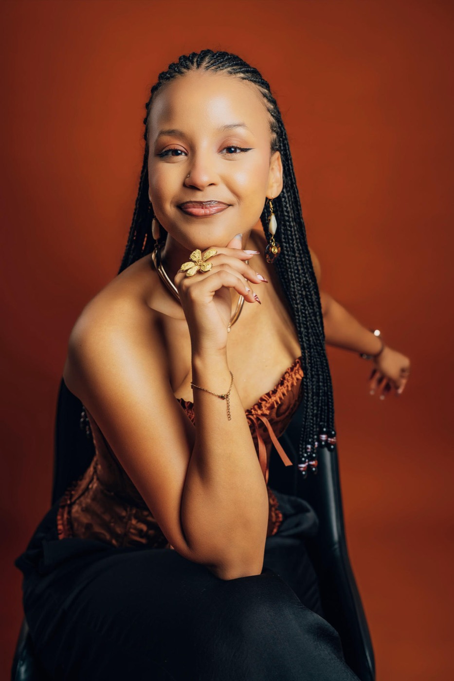 Marlène seated, chin resting on her hand, smiling gently